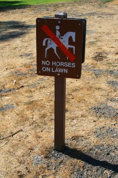 No horses on lawn sign in a park.
