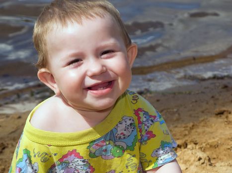 Little child smiling on water beach at summer