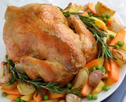 Baked chicken with vegetables and whole rosemary

