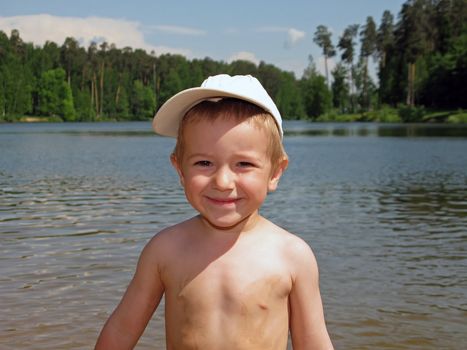 Little child smiling on water beach at summer