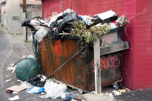 overfilled trash dumpster in ghetto neigborhood