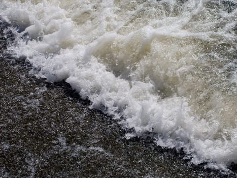 Wave of sea and water foam on beach at summer