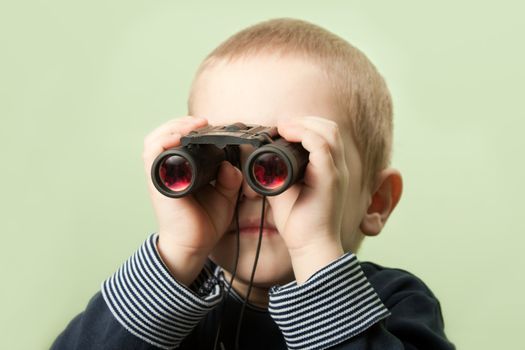 Little child boy looking binoculars lens isolated