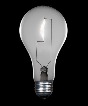 Glass incandescent tungsten filament light bulb due to be replaced due to energy concerns. Image is isolated on black with an isolation path around bulb