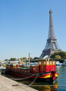 Panoramic view of a red living barge on the Seine in Paris with Eiffel tower backround. France