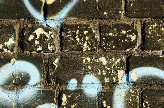 Background closeup of graffitti painted brick wall. Architectural dirty backdrop.