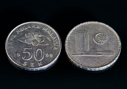 Malaysian currency coins on a black mirror surface