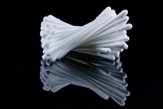 cotton wool buds on black mirror with mirror image and black background