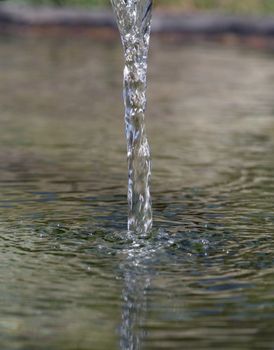 Fresh water ripple pouring down into water surface.