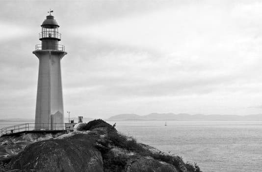Black and White Photo of Ocean shore with Classic Lighthouse