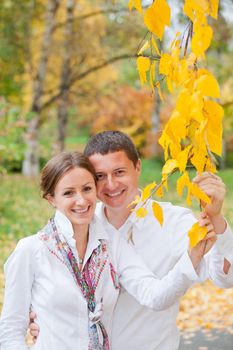 Portrait of romantic happy young beautiful couple on autumn walk. Vertical view