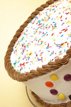 A decorated cake rests on a yellow background to celebrate an occasion.