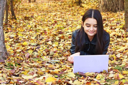 Teenager laying on leaf in the park-Autumn.