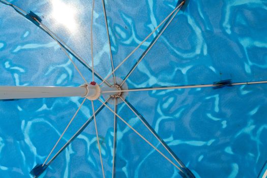 Beach umbrella parasol against sunny clear blue summer sky 