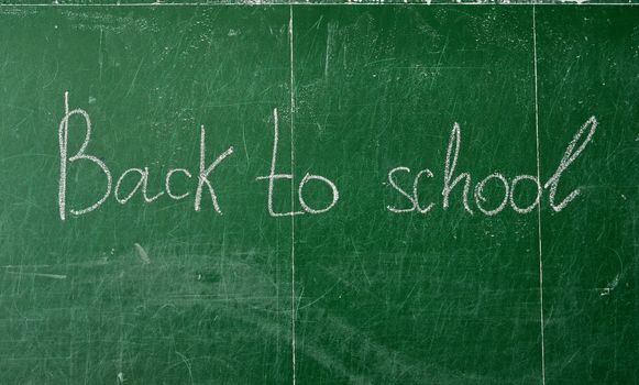 Green chalk blackboard written Back To School with white chalk