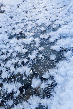 Beautiful closeup of big icy snowflakes on frosted stream