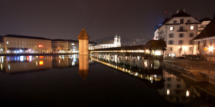 Panorama of Lake Lucern and Famous wooden Chapel bridge foot walkway Switzerland at Night