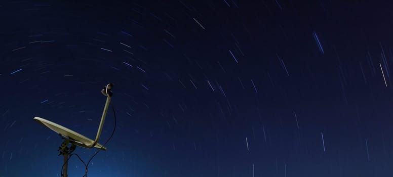 Conceptual of yellow satellite over spiral star at night