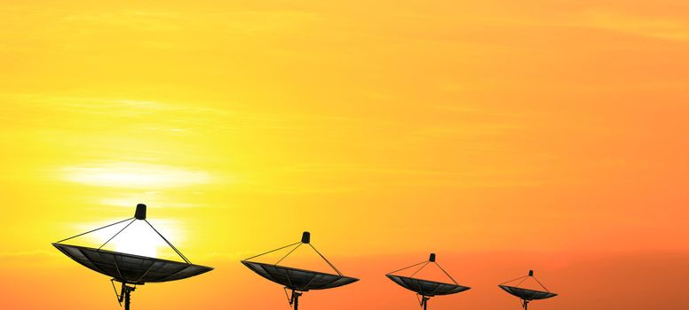 black antenna communication satellite dish over sunset sky