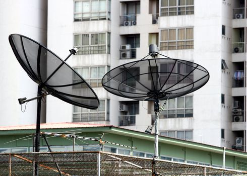 two Satellite Dishes on building for telecommunication concept