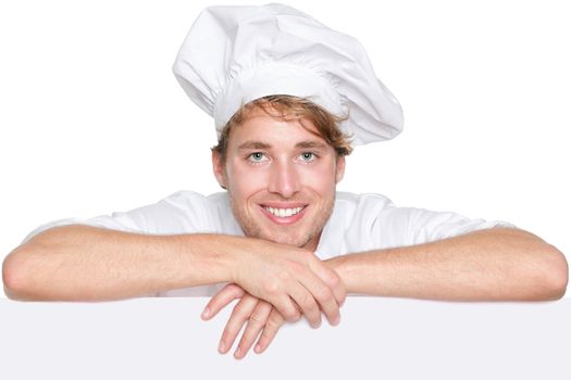 Chef sign. Man chef, cook or baker holding blank white paper billboard sign with copy space for text or menu. Young Caucasian male chef smiling happy isolated on white background.