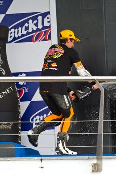 JEREZ DE LA FRONTERA, SPAIN-NOV 20: 125cc motorcyclist Alex Rins on the podium like winner of the 125cc CEV Championship celebrating with champagne on November 20, 2011, in Jerez de la Frontera, Spain