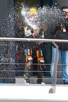 JEREZ DE LA FRONTERA, SPAIN-NOV 20: 125cc motorcyclist Alex Rins on the podium like winner of the 125cc CEV Championship celebrating with champagne on November 20, 2011, in Jerez de la Frontera, Spain