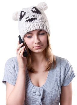 Beautiful girl in winter hat with telephone on white background