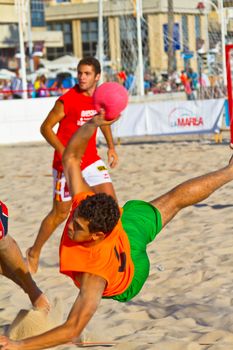 CADIZ, SPAIN - JULY 19: Unidentified players compete in a match between Los Negritos and Autoescuela Barquin in the 19th league of beach handball of Cadiz on July 19, 2011 in Cadiz, Spain