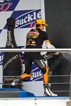 JEREZ DE LA FRONTERA, SPAIN-NOV 20: 125cc motorcyclist Alex Rins on the podium like winner of the 125cc CEV Championship celebrating with champagne on November 20, 2011, in Jerez de la Frontera, Spain