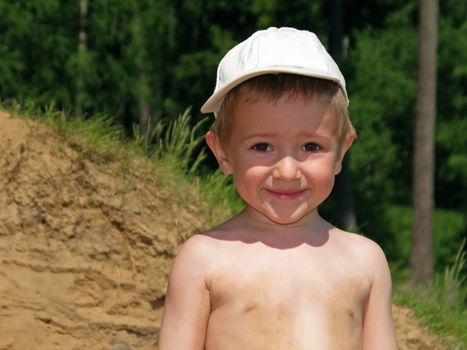 Little child smiling on water beach at summer