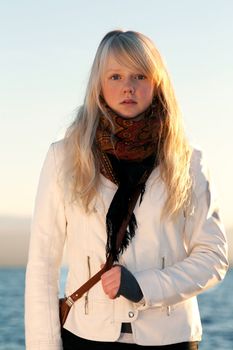 Beautiful blonde on background blue sky in ray sunshine