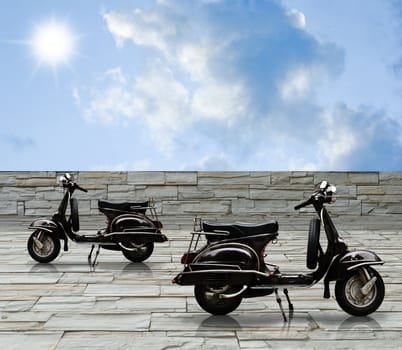 Black vintqage motorbike on decorate stone road with blue sky.