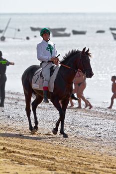 SANLUCAR DE BARRAMEDA, CADIZ, SPAIN - AUGUST 10: Unidentified rider at the start of race horses on Sanlucar de Barrameda beach on August 10, 2011 in Sanlucar de Barrameda, Cadiz, Spain.