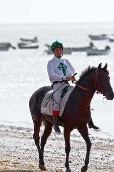 SANLUCAR DE BARRAMEDA, CADIZ, SPAIN - AUGUST 10: Unidentified rider at the start of race horses on Sanlucar de Barrameda beach on August 10, 2011 in Sanlucar de Barrameda, Cadiz, Spain.
