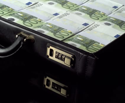 Briefcase with money isolated on black background