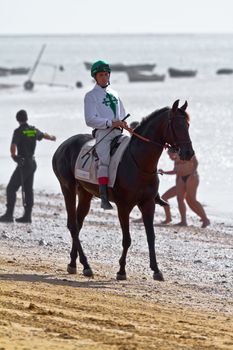 SANLUCAR DE BARRAMEDA, CADIZ, SPAIN - AUGUST 10: Unidentified rider at the start of race horses on Sanlucar de Barrameda beach on August 10, 2011 in Sanlucar de Barrameda, Cadiz, Spain.