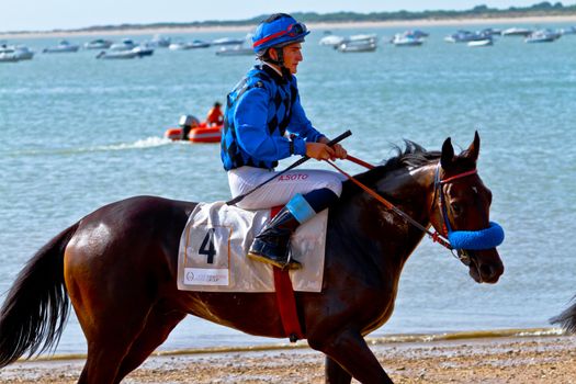 SANLUCAR DE BARRAMEDA, CADIZ, SPAIN - AUGUST 10: Unidentified rider at the start of race horses on Sanlucar de Barrameda beach on August 10, 2011 in Sanlucar de Barrameda, Cadiz, Spain.