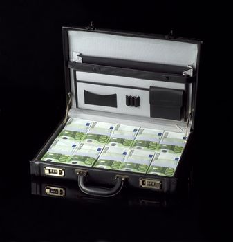 Briefcase with money isolated on black background