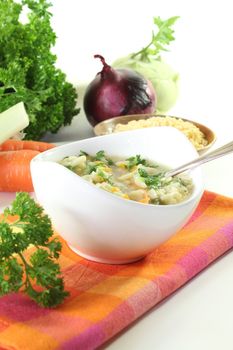 Alphabet soup with carrots, leeks, onions, parsley and spoon