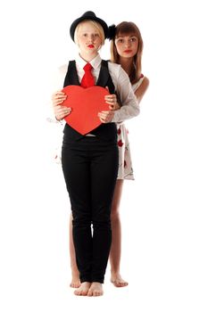 Two girls with red cardboard heart on white background