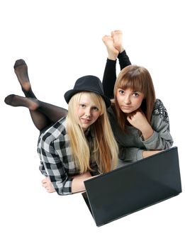 Two girls lies with computer on white background