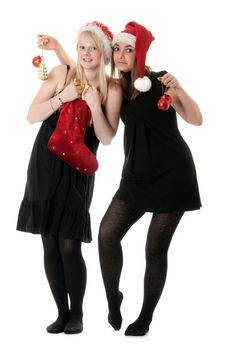 Two girls in the Santa hat and gifts on white background