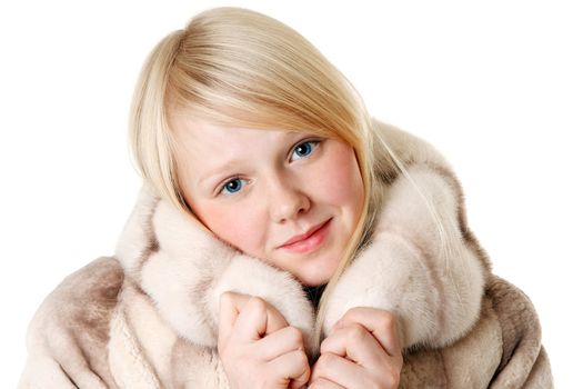 Blonde girl with blue eyes wearing a fur coat on a white background