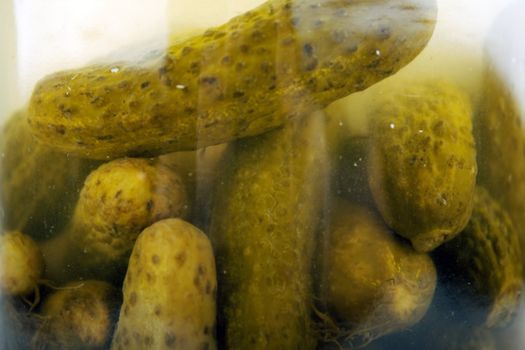 Green pickled cucumber vegetable food in glass jar