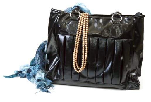 Feminine bag with scarf and necklace on white background