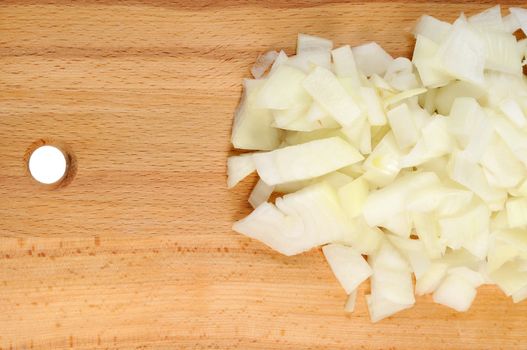 Chopped onions on a wooden board.