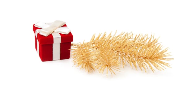 Red and gold gift box with fir branches on a white background