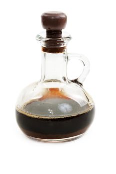 Glass bottle with soy sauce on white background