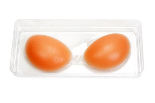 Silicone bra in a transparent box on white background